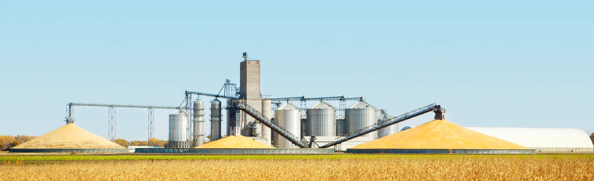 An industrial size silo in the middle of the field.
